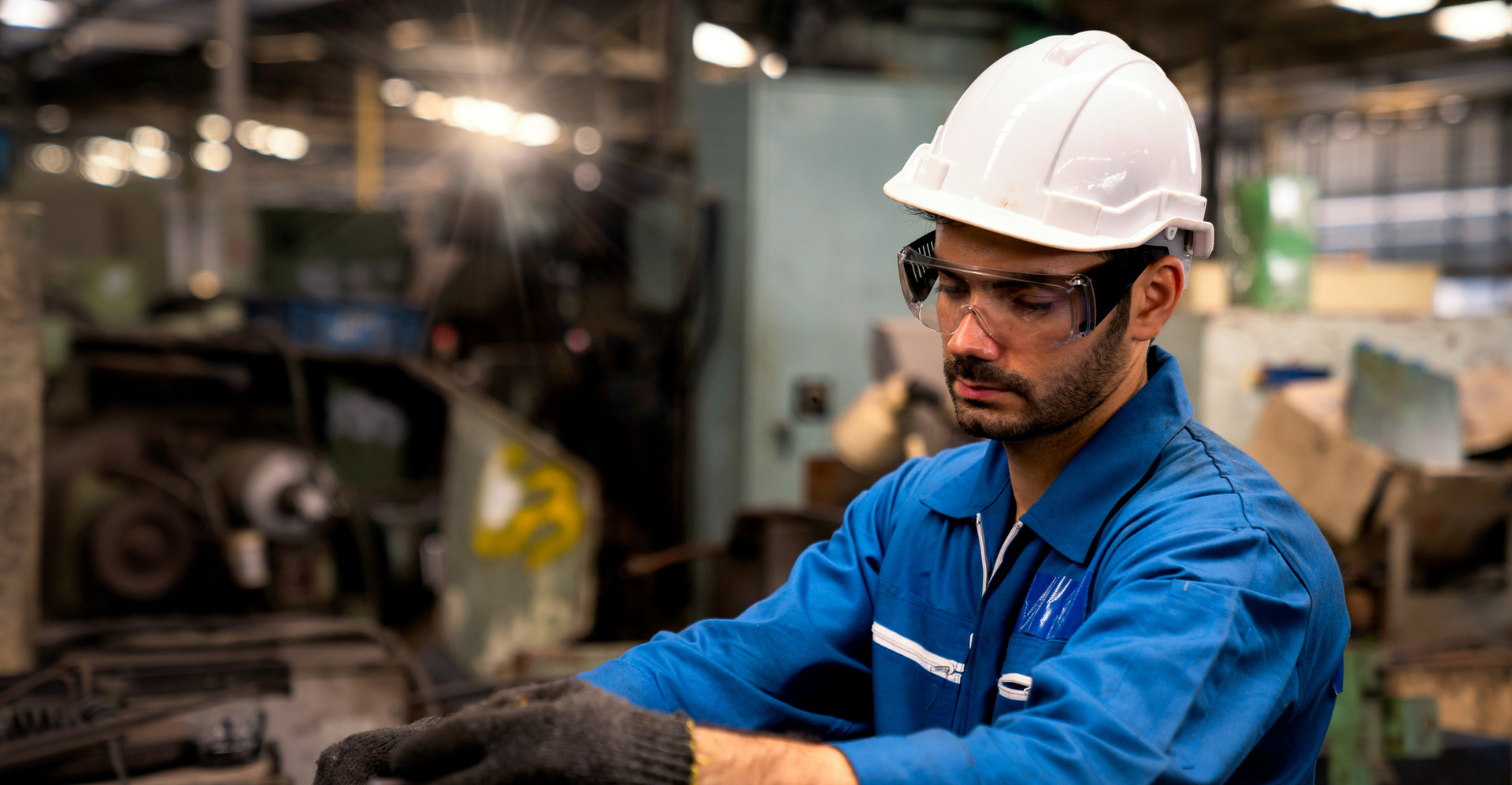 engineer wearing a helmet, working on a piece of machinery